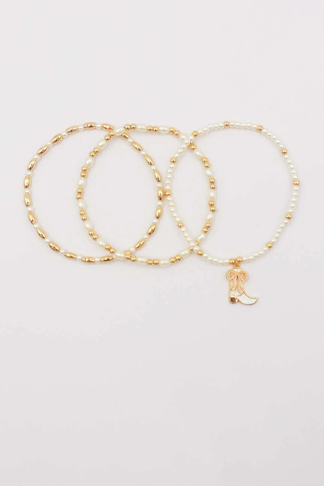 Set of Three Gold and Pearl Stretch Bracelets with Light Pink Bow on White Cowboy Boot Charm