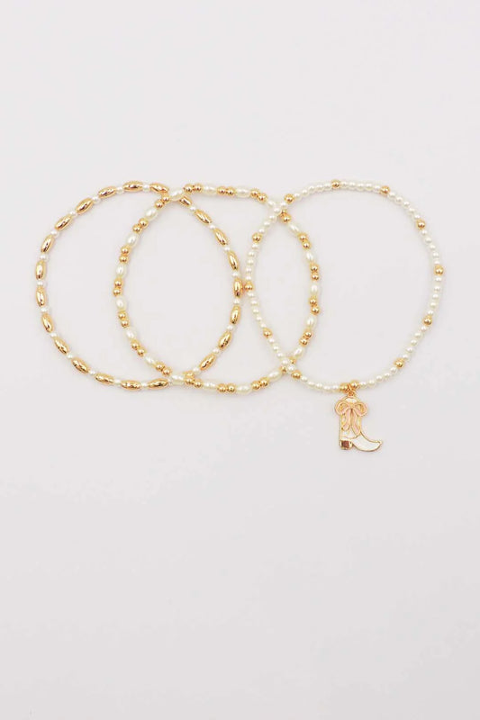 Set of Three Gold and Pearl Stretch Bracelets with Light Pink Bow on White Cowboy Boot Charm